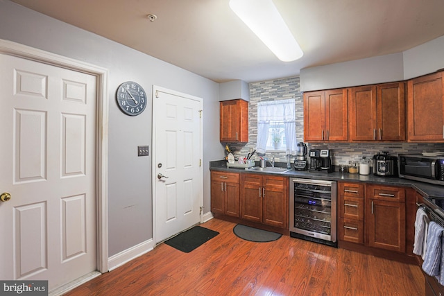 kitchen featuring wine cooler, dark hardwood / wood-style floors, tasteful backsplash, and sink