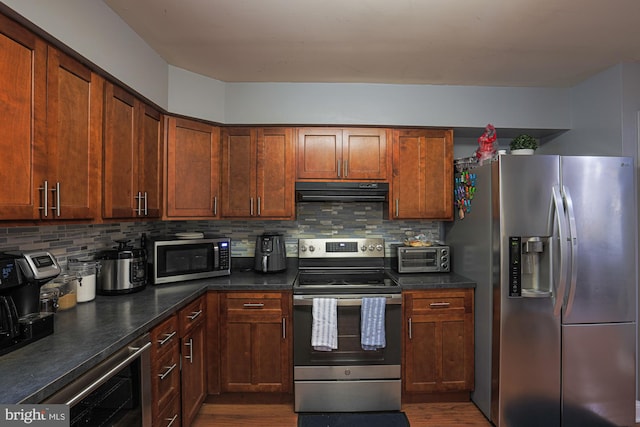 kitchen with decorative backsplash, dark hardwood / wood-style floors, stainless steel appliances, and exhaust hood