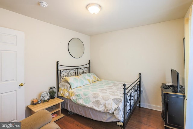 bedroom with dark hardwood / wood-style floors