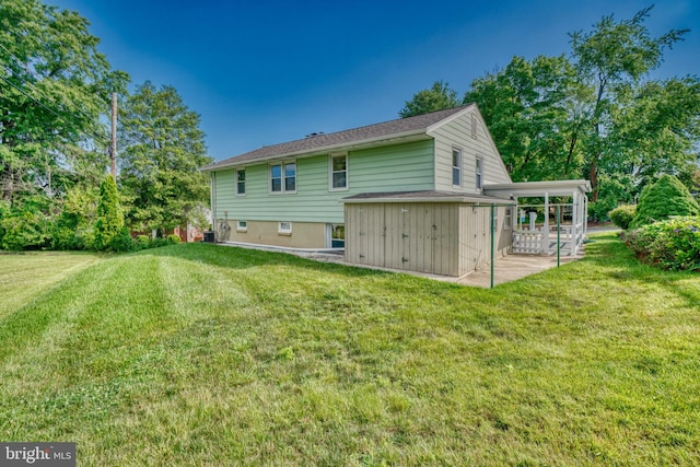 back of house featuring a patio area and a lawn