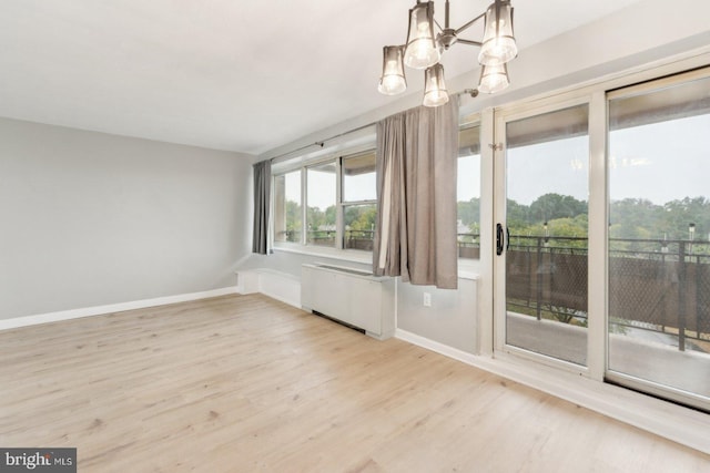 unfurnished dining area with radiator, a chandelier, and light hardwood / wood-style floors