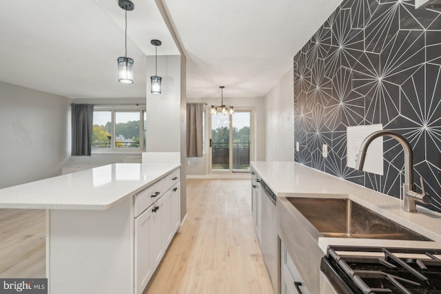 kitchen featuring appliances with stainless steel finishes, white cabinets, a kitchen island, and plenty of natural light