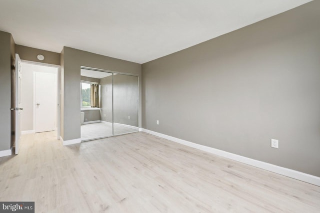 unfurnished bedroom featuring a closet and light hardwood / wood-style floors