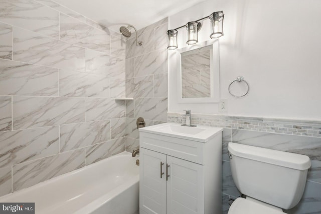 full bathroom featuring vanity, tile walls, tiled shower / bath combo, and toilet