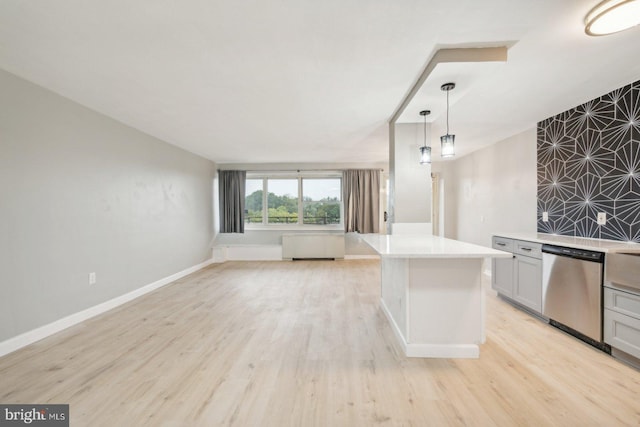 kitchen with radiator heating unit, light wood-type flooring, decorative light fixtures, and stainless steel dishwasher