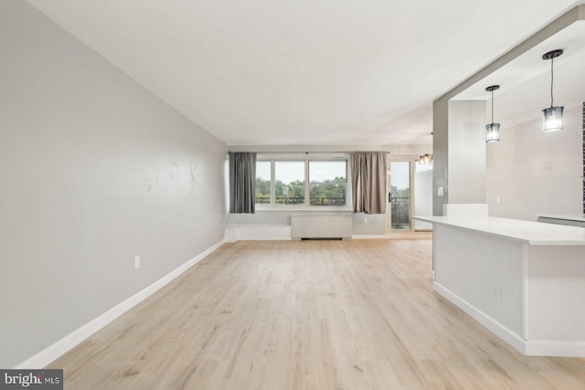 unfurnished living room with light wood-type flooring and radiator heating unit