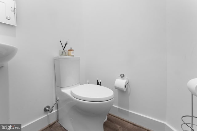 bathroom featuring wood-type flooring and toilet