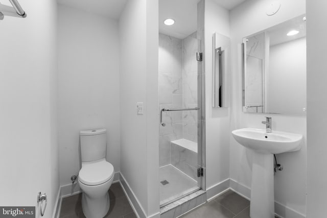 bathroom featuring tile patterned floors, an enclosed shower, toilet, and sink