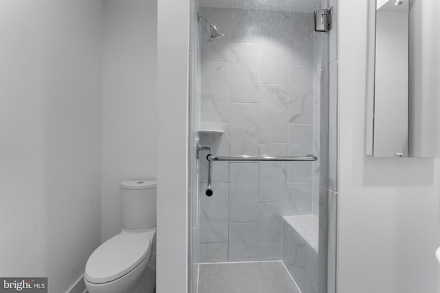 bathroom with a shower with door and toilet