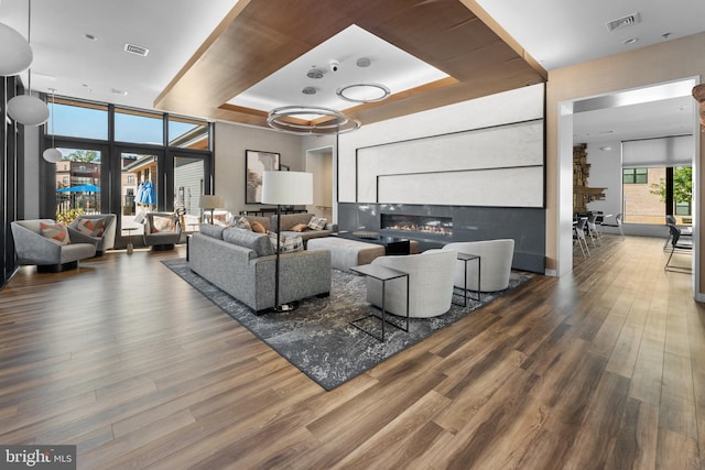 living room with a tray ceiling and hardwood / wood-style flooring