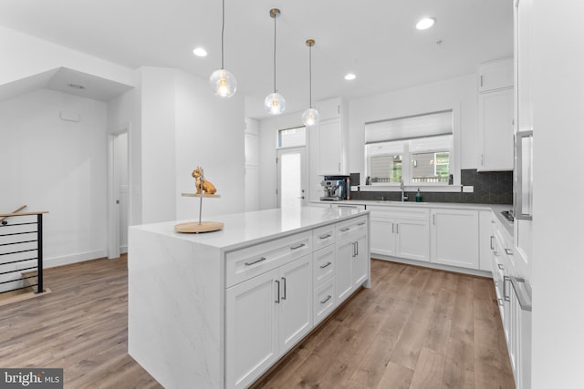 kitchen with a center island, light hardwood / wood-style floors, and white cabinets