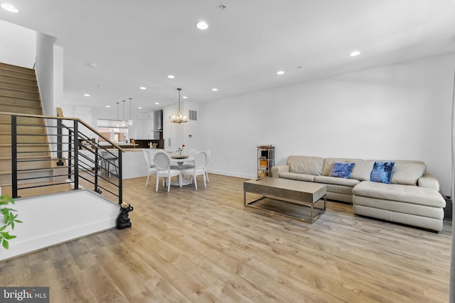 living room with an inviting chandelier and light hardwood / wood-style flooring