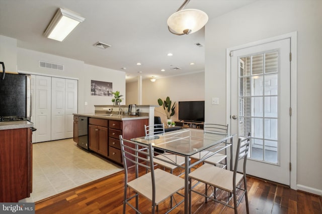 dining area featuring sink, light hardwood / wood-style flooring, and a wealth of natural light