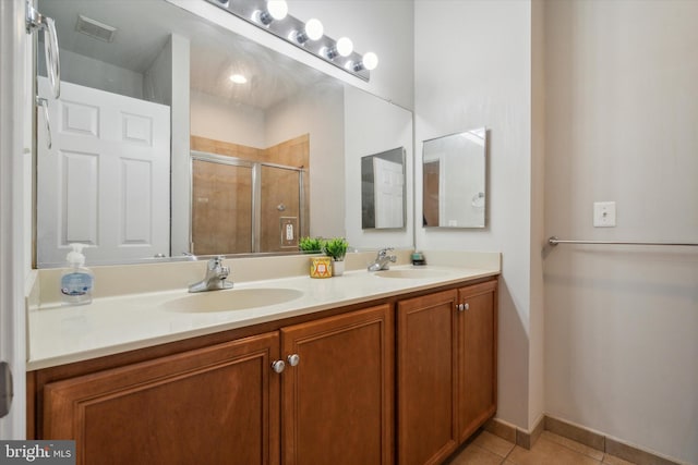 bathroom with tile patterned flooring, vanity, and a shower with shower door