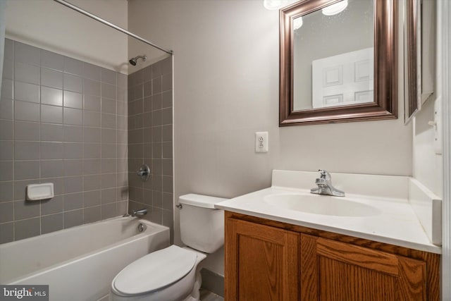 full bathroom featuring tiled shower / bath, vanity, and toilet