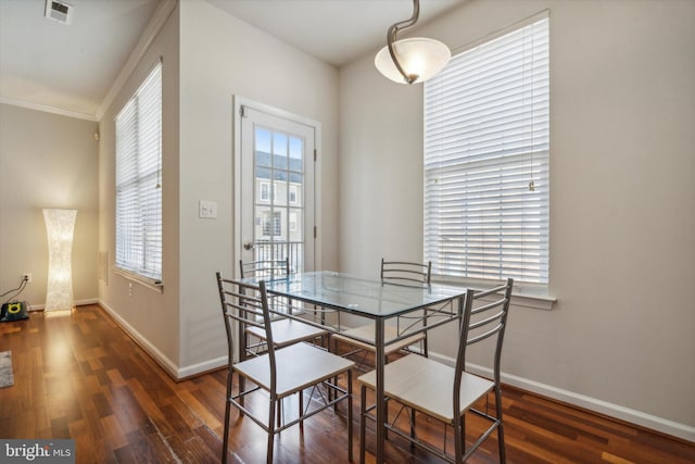 dining area with crown molding and dark hardwood / wood-style flooring