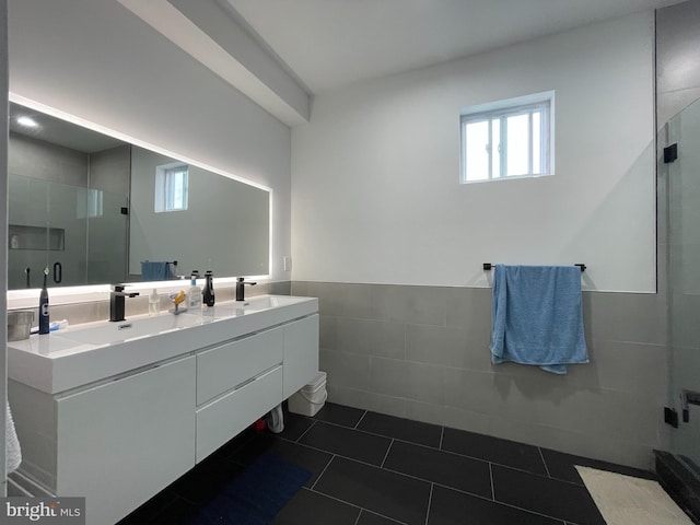 bathroom featuring tile walls, tile patterned flooring, walk in shower, and vanity