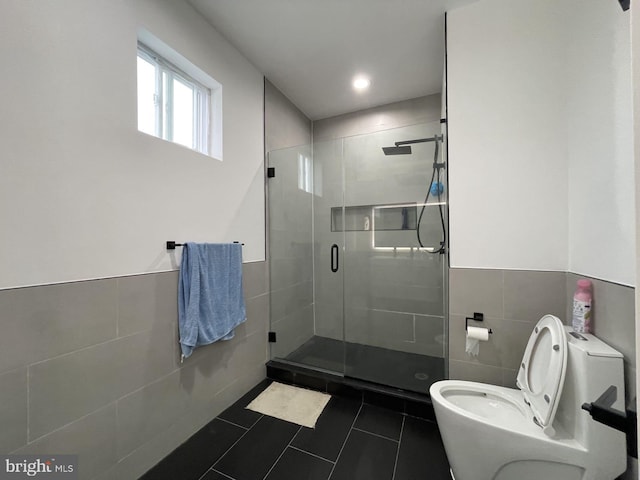 bathroom with walk in shower, tile walls, toilet, and tile patterned floors