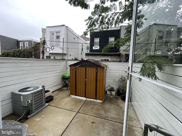 view of patio / terrace featuring central AC unit and a storage unit