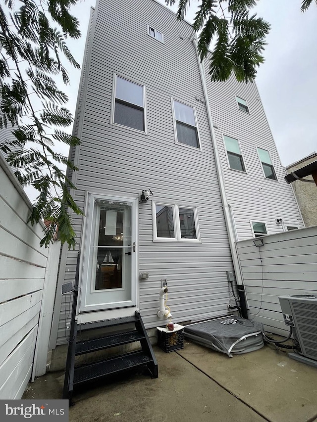 back of property with a patio and central AC