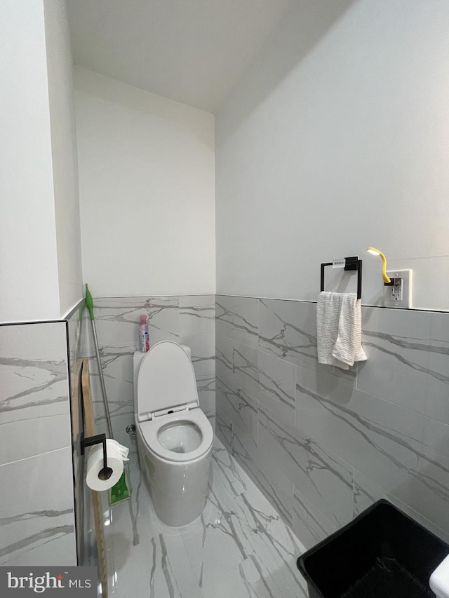 bathroom with tile walls and toilet