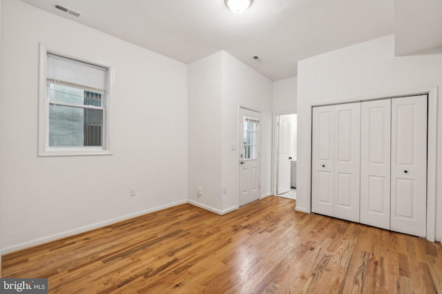 unfurnished bedroom featuring light wood-type flooring and a closet