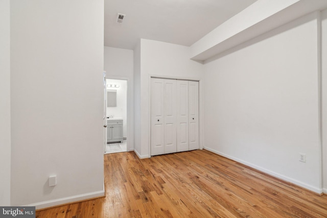 unfurnished bedroom with light hardwood / wood-style flooring and a closet