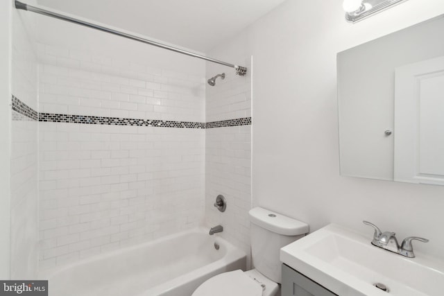 full bathroom with tiled shower / bath, vanity, and toilet