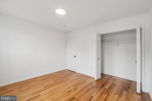 unfurnished bedroom featuring a closet and hardwood / wood-style flooring