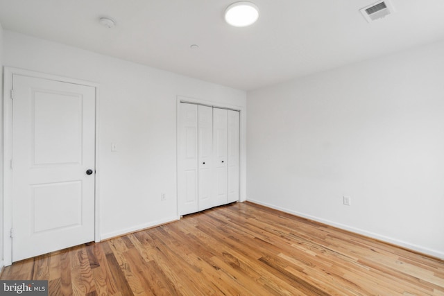 unfurnished bedroom featuring light hardwood / wood-style flooring and a closet