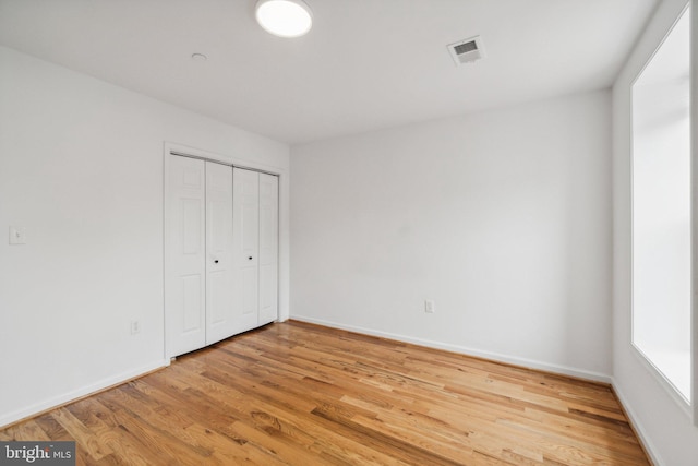 unfurnished bedroom with hardwood / wood-style floors and a closet