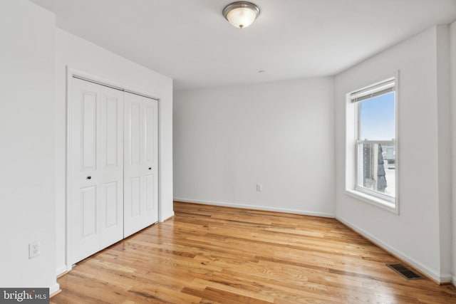 unfurnished bedroom featuring light hardwood / wood-style flooring and a closet