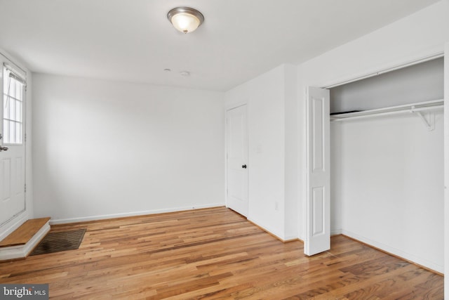 unfurnished bedroom with wood-type flooring and a closet