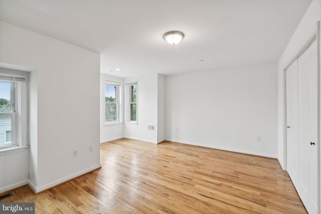 unfurnished bedroom featuring light hardwood / wood-style flooring and multiple windows