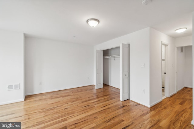 unfurnished bedroom featuring a closet and light hardwood / wood-style floors