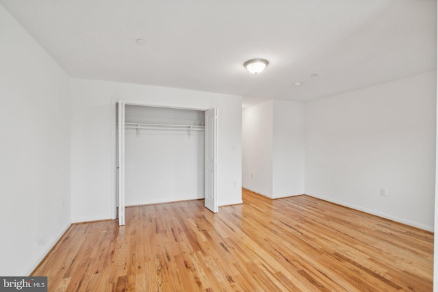 unfurnished bedroom with a closet and light hardwood / wood-style floors