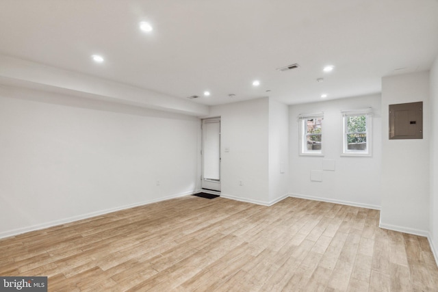 unfurnished room with light wood-type flooring and electric panel