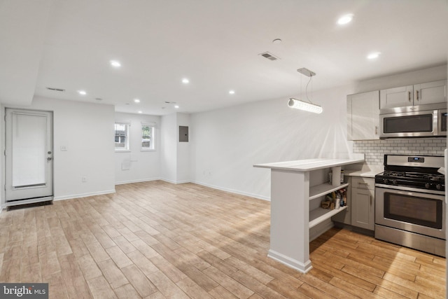 kitchen featuring decorative backsplash, light hardwood / wood-style floors, kitchen peninsula, pendant lighting, and stainless steel appliances