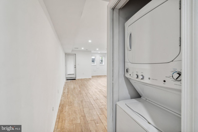 washroom featuring light hardwood / wood-style flooring and stacked washer and dryer