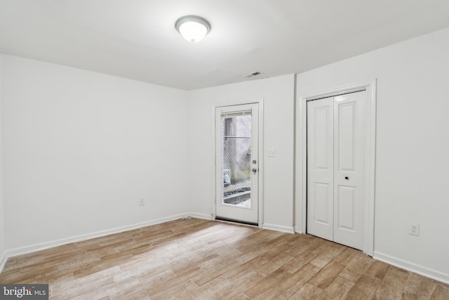 unfurnished bedroom with a closet and light hardwood / wood-style floors