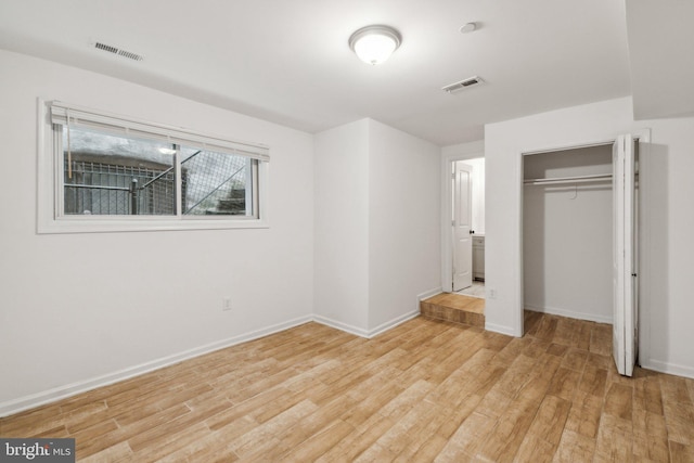 unfurnished bedroom with light wood-type flooring and a closet