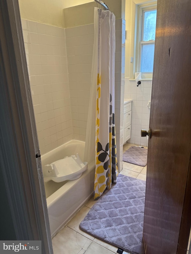 bathroom with tile walls, tile patterned flooring, and shower / tub combo