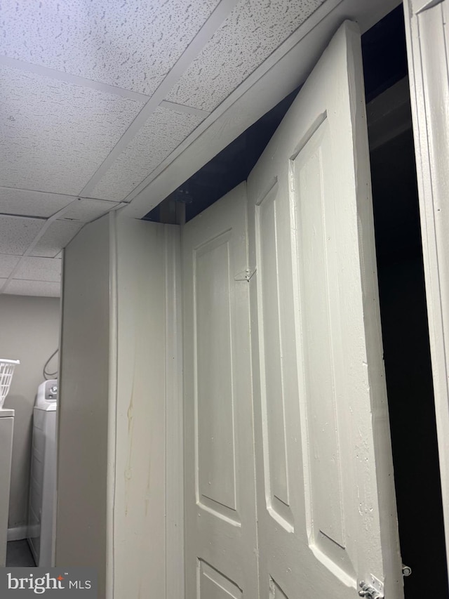 room details with washer and clothes dryer and a paneled ceiling