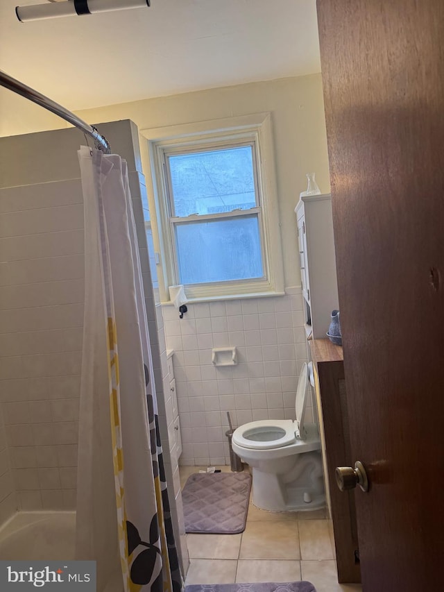 bathroom featuring a shower with shower curtain, tile walls, toilet, and tile patterned floors