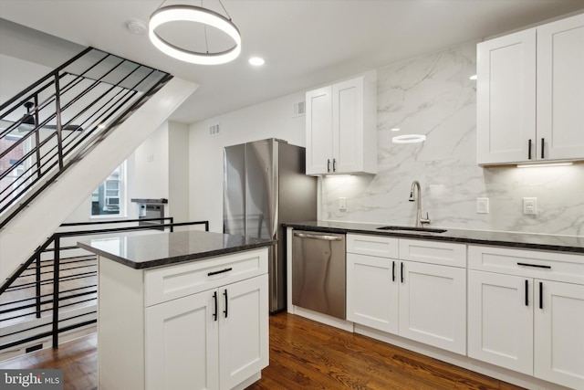 kitchen with white cabinets, sink, backsplash, stainless steel appliances, and dark hardwood / wood-style floors