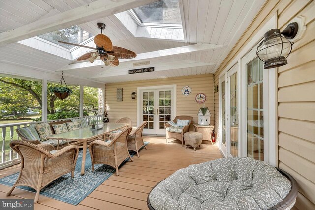 sunroom featuring ceiling fan, wood ceiling, and lofted ceiling with skylight