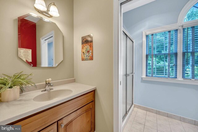 bathroom featuring vanity, a shower with shower door, and tile patterned flooring