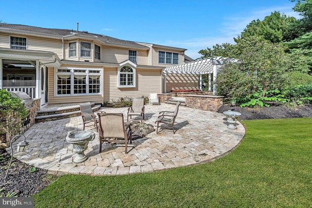 back of house featuring a pergola, a yard, a patio, and a fire pit