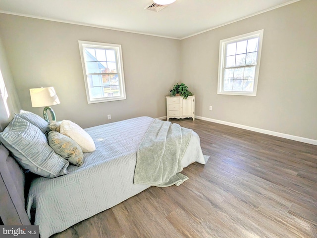 bedroom featuring wood-type flooring and ornamental molding