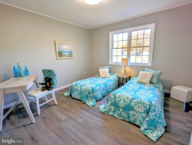 bedroom featuring crown molding and wood-type flooring